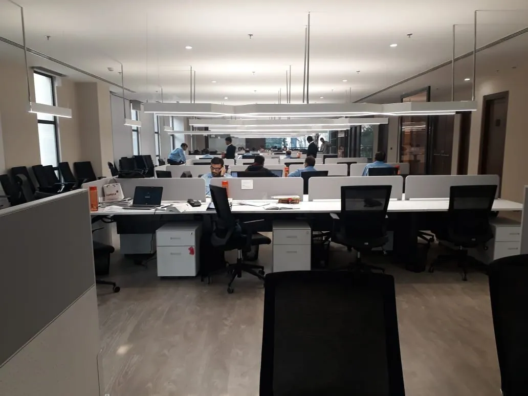 Open-plan office lit by suspended linear luminaires